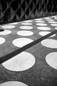 Abstract pattern of circles on urban pavement with minimal geometry texture and bold contrast creating a clean background for copy space layouts