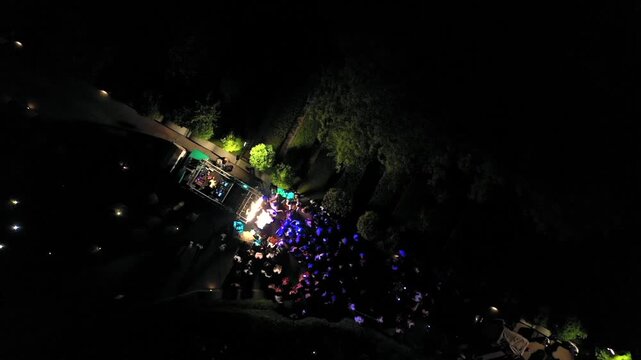 Aerial night shot of a traditional Indian wedding baraat with decorated car, dancers, and festive lights in india