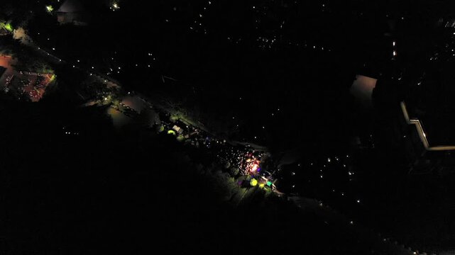 Aerial night shot of a traditional Indian wedding baraat with decorated car, dancers, and festive lights in india