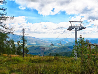 Fototapeta premium The picturesque landscape from the mountain trail captures the essence of nature's beauty, featuring a ski lift gracefully positioned amid lush rolling hills