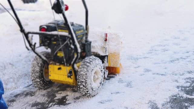 Removing snow with portable blower machine during winter, worker with gas snow blower removal in the streets after snowfall, clearing residential sidewalk driveway with snow sweeper, snowplow machine