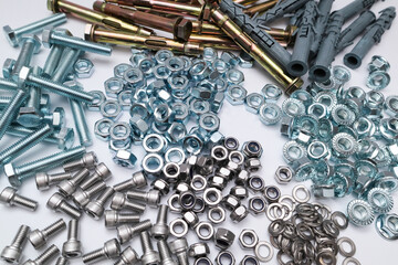 Assorted industrial fasteners including bolts, nuts, screws, and sleeve anchors on white.