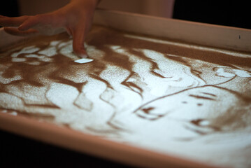 Hand Drawing Portrait Shape In Illuminated Sand Surface
