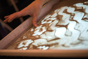 Soft Motion Of Hands Creating Abstract Shapes In Illuminated Sand Surface Scene