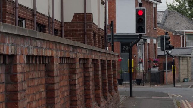 British style traffic light turning red with passing car and twisted post