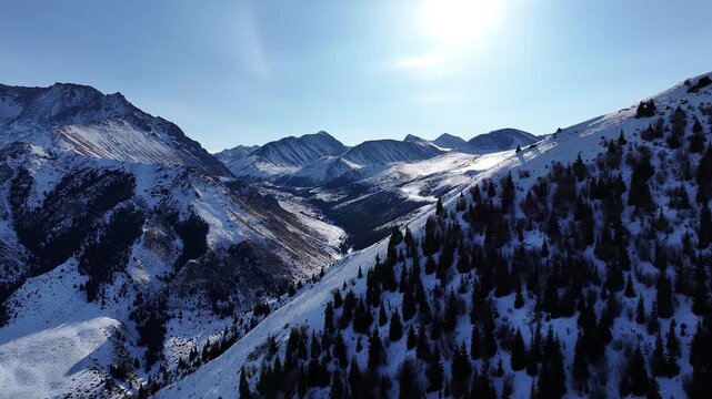 Aerial flight over a majestic snow covered Dzungarian Alatau mountain range
