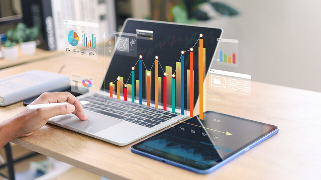 Business professional analyzing financial growth data on laptop with virtual dashboard and colorful bar charts. Concept of digital analytics, performance tracking, investment growth.