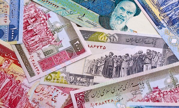 Iranian rial money bills pile on table. Iran banknotes of IRR currency close up.