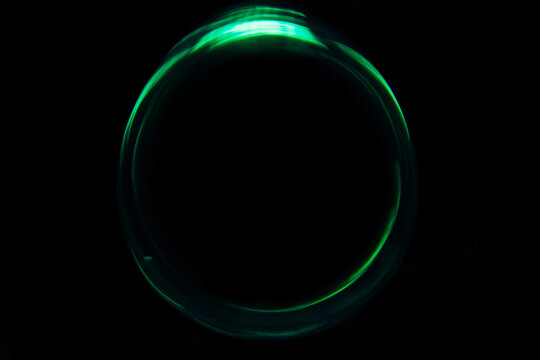 A green circular light spot on a black background