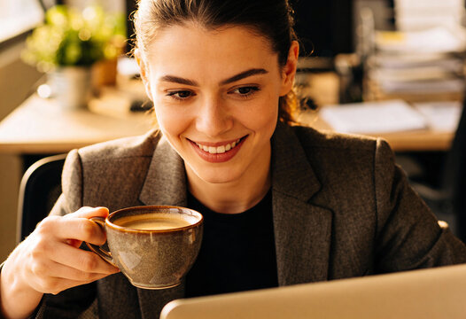 Frau im B&uuml;ro mit einer Kaffeetasse