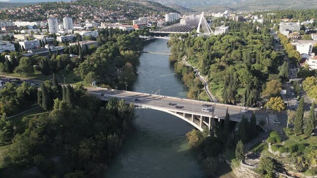 Water of Moraca river passing under an road bridge in Podgorica, Montenegro. Aerial perspective, drone video.