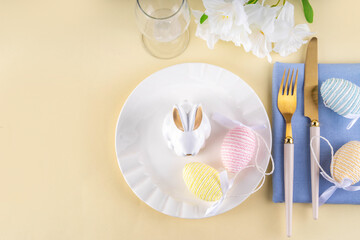Cute  Easter table setting with bunny, Easter egg, napkin and spring flowers