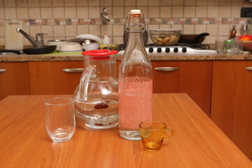 Kitchen table with water pitcher bottle and glasses