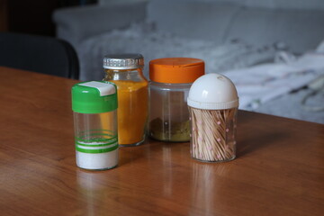 Salt shaker, spices, toothpicks on wooden table