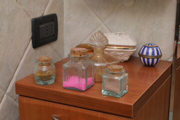 Glass jars with bath salts on wooden vanity