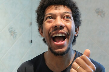 Young black man laughing looking up feeling happy