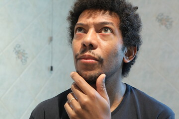 Man thinking and contemplating with hand on chin