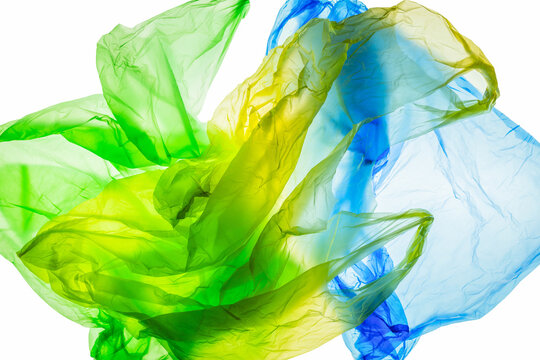 Discarded disposable plastic bags in an aesthetic presentation: colorful disposable plastic bags crumpled up and jumbled together against the light