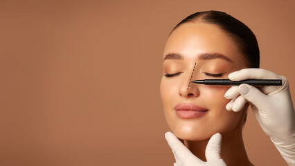 Doctor making marks on female nose, young woman posing on beige studio background with closed eyes...
