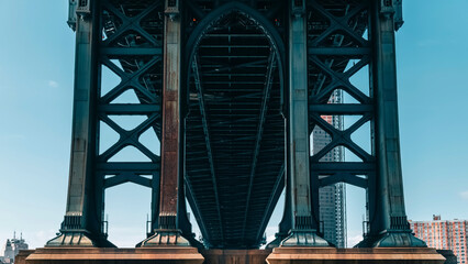 View of the Manhattan Bridge structure and steel arches from underneath on a clear day