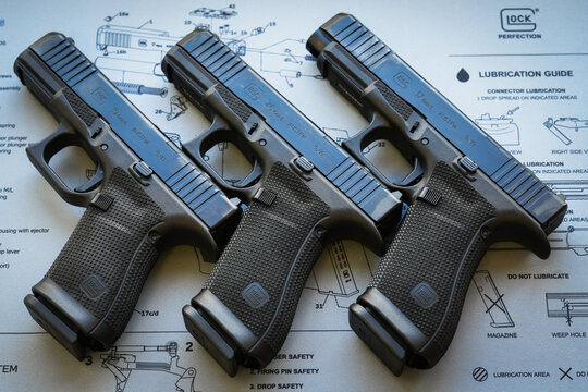 Tallinn, Estonia - February 20, 2026: Three Glock Gen 6 pistols, models 19, 45, and 17, displayed on a technical mat.