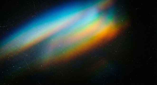 Vibrant rainbow light beam shining diagonally across a dark background with colorful spectrum