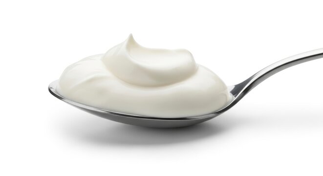 Close-up of a dollop of fresh, creamy white yogurt or sour cream on a silver spoon, isolated on a clean white background.