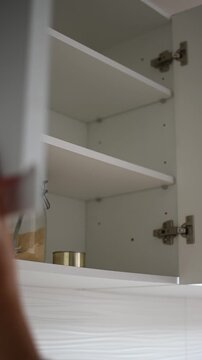 Woman opening almost empty pantry, food shortage and inflation concept