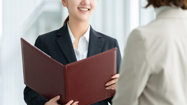 資料を使って説明を行うビジネスウーマン, Businesswoman explaining documents during a meeting