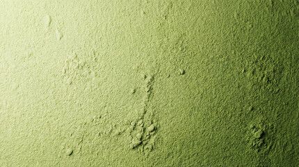 Macro texture of green powder spread in an even layer with subtle bumps. Clean, minimal look suitable for cosmetic textures and natural ingredient backgrounds.