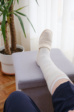 Person elevating bandaged leg resting for recovery