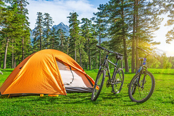 camping with tent and bicycles near mountains in summer