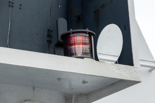 A red navigational light on a big ship