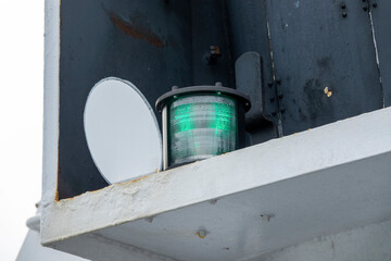 A green navigational light on a big ship