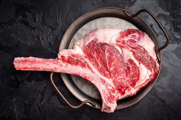 Raw tomahawk steak with marbling, fresh rib eye with bone. black background. top view © Mironov