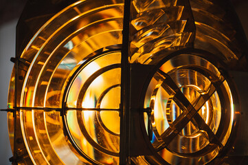 Lighthouse lamp with Fresnel lens mounted on metal frame glow in the dark, close up photo with soft...