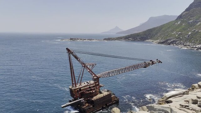 Drone flies north over Bos 400 shipwreck in Hout Bay on a sunny morning in Cape Town, South Africa