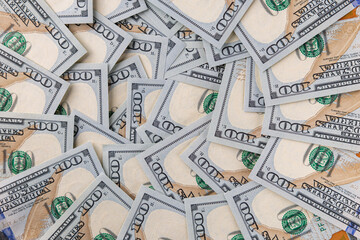 Background of Scattered One Hundred US Dollar Bills Representing Wealth and Finance