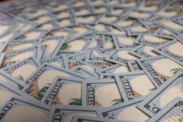Obraz premium Background of Scattered One Hundred US Dollar Bills Representing Wealth and Finance