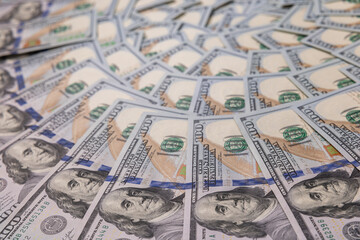 Background of Scattered One Hundred US Dollar Bills Representing Wealth and Finance