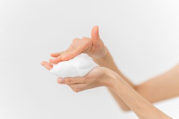 スキンケアプロセス。洗顔フォームの泡を手にのせている手元。