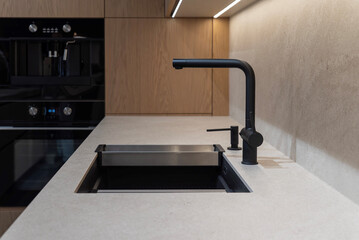 Black composite kitchen sink with matte faucet and soap dispenser