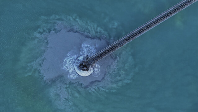 Aerial view of the Morenci Mine Tailings Dam, a stark contrast between turquoise waters and grey sediment plumes, Greenlee County, Arizona, United States.