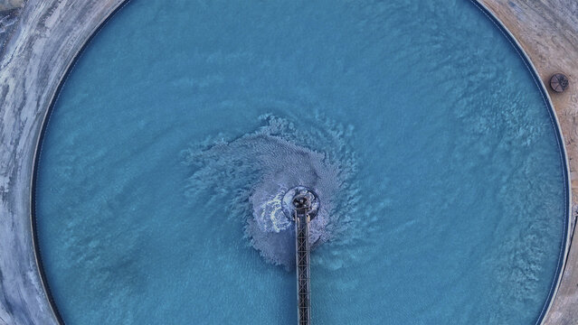 Aerial view of a circular pond with turquoise water and a central structure creating swirling patterns, Arizona, United States.
