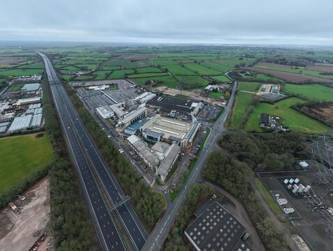 Enderby, United Kingdom - 08 February 2026: Aerial view of the Next Head Office, with its sprawling architecture juxtaposed against the verdant fields, under a muted, overcast sky.