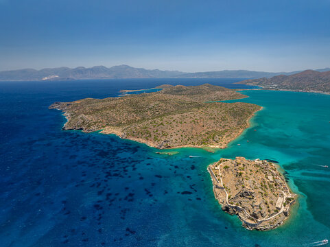 Aerial view of the island fortress with its weathered stone walls embraced by the turquoise sea, Spinalonga, Lasithi, Greece.