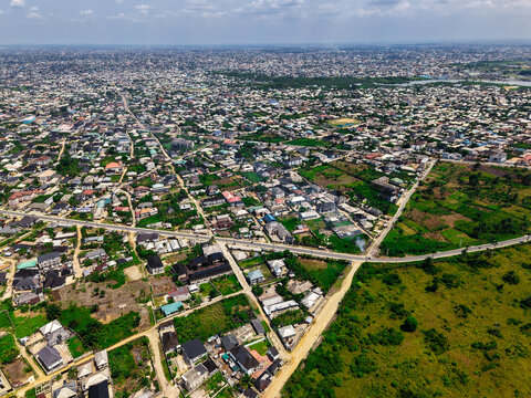 Aerial view of a vibrant cityscape with lush greenery interspersed among the buildings and roads, creating a mosaic of urban and natural textures, Port Harcourt, Rivers, Nigeria.