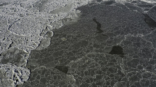 Aerial view of a frozen landscape where ice patterns create a mesmerizing mosaic of light and shadow, Highlands, New Jersey, United States.