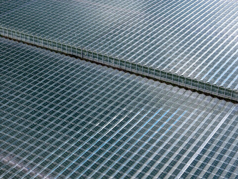Aerial view of a reflective, metallic grid pattern stretching across the frame, creating a mesmerizing industrial tableau, Tredarzec, Bretagne, France.