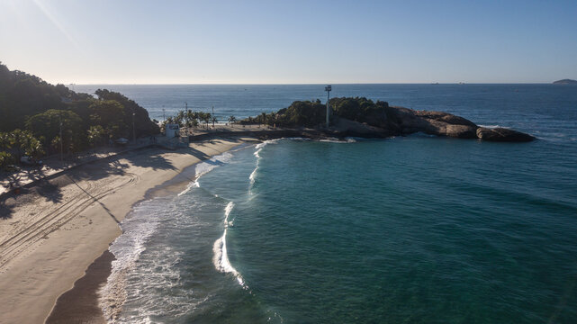 Aerial view of the sun-kissed sands meet the turquoise waters at Arpoador Beach, where a rocky peninsula juts into the ocean, Rio de Janeiro, State of Rio de Janeiro, Brazil.